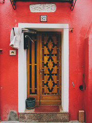 Front door of a red home in Burano
