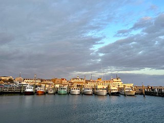 Block Island's Old Harbor is home to numerous fishing boats. Here are a few, along with the Block Island ferry in the background and the hotels, shops, and restaurants on Water Street, lined up at sunrise. #blockislandlife #blockisland
