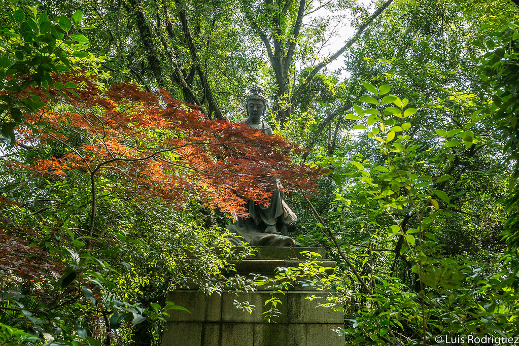 Estatua de Bishamonten entre frondosa vegetación