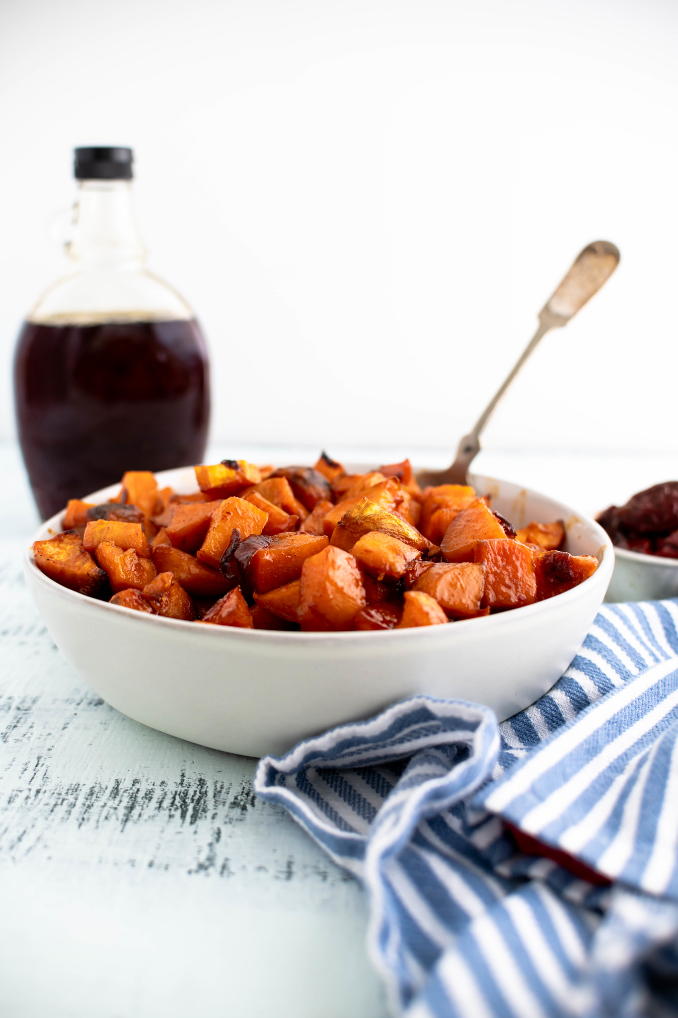 Cream colored bowl filled with roasted chipotle sweet potatoes.