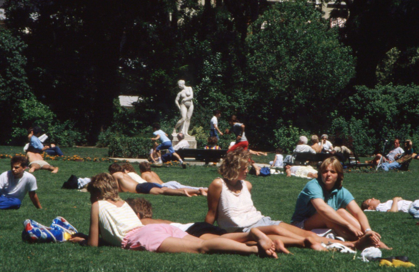 Молодые парижане лежат на лужайке парижского парка
