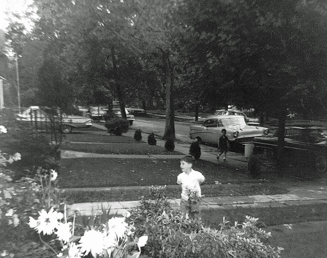 One of the earliest photos I ever shot. We were visiting some of my parent's friends. To a 7 year old, the adult chatter became boring pretty quickly, so I went outside where this view of kids and parked cars was taken. May 1966.