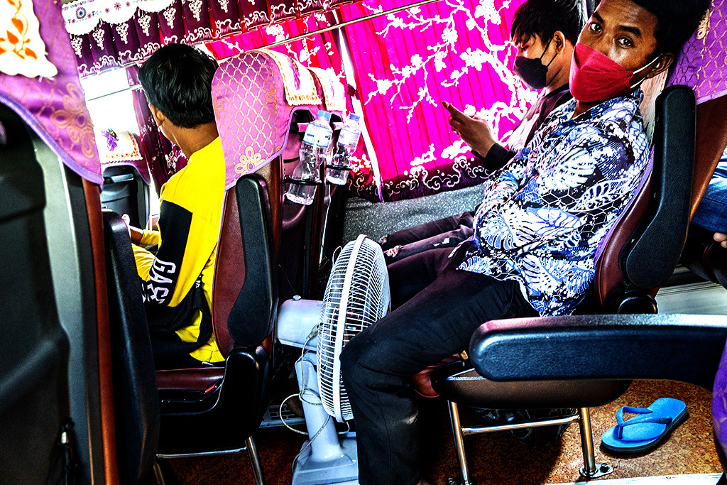Man with fan between legs on bus to Siem Reap on 11-15-22--Phnom Penh copy