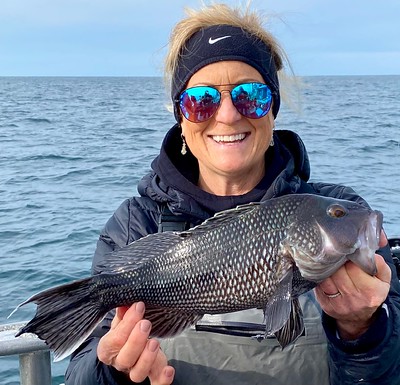 Photo of woman holding a black sea bass