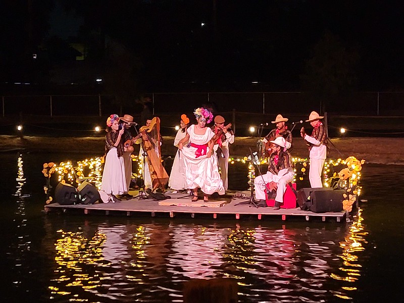 A floating mariachi and traditional dancers in the sall lake as decorated boats circle  in Calaveradia 2022