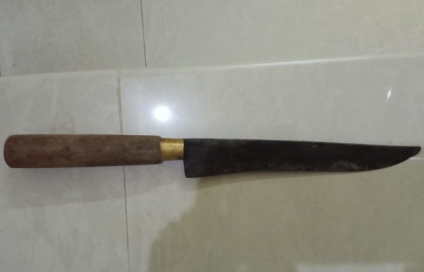 kitchen knife long sharp black blade brass ring wood handle on white tile