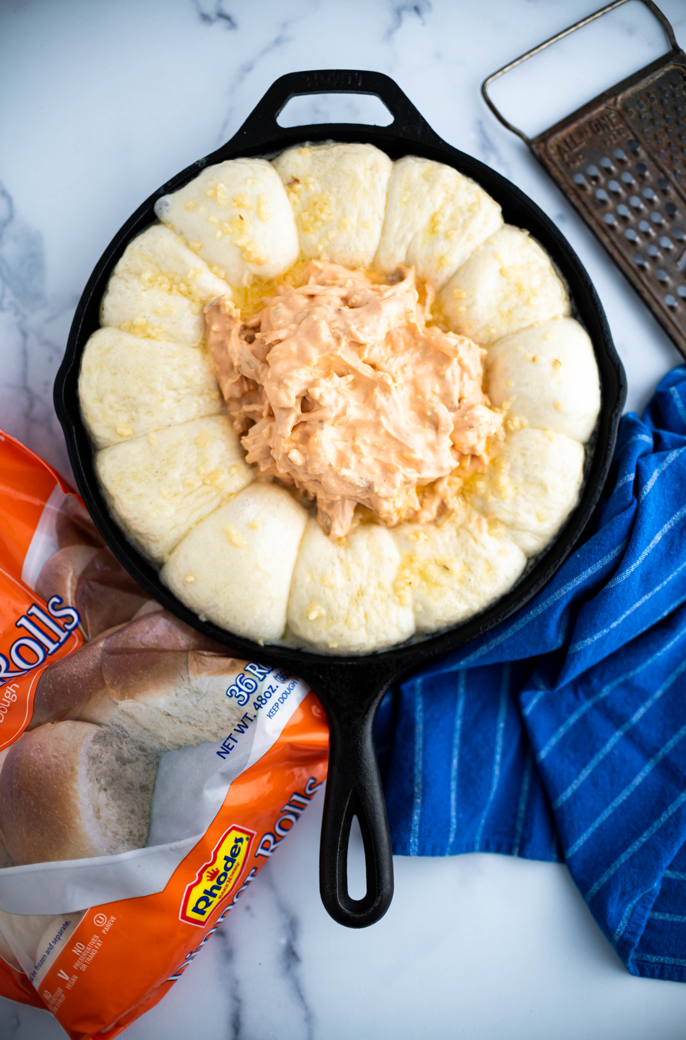 Risen Rhodes rolls brushed with garlic butter and buffalo chicken dip in the middle.