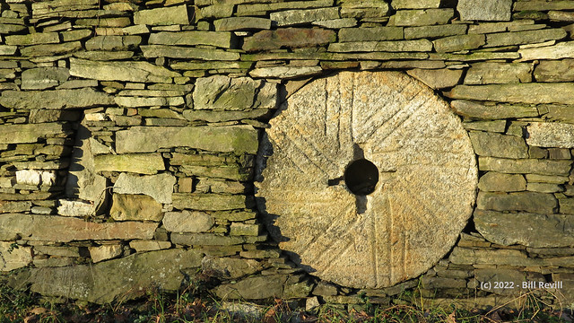 Millstone in stone wall