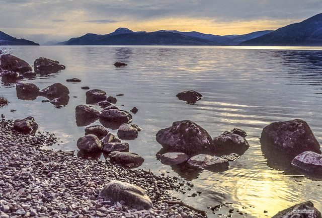 Rocky north shore of Loch Ness looking towards Urquhart Bay and Meall-fhuar Mhonaidh at sunset, Inverness-shire, Scotland.