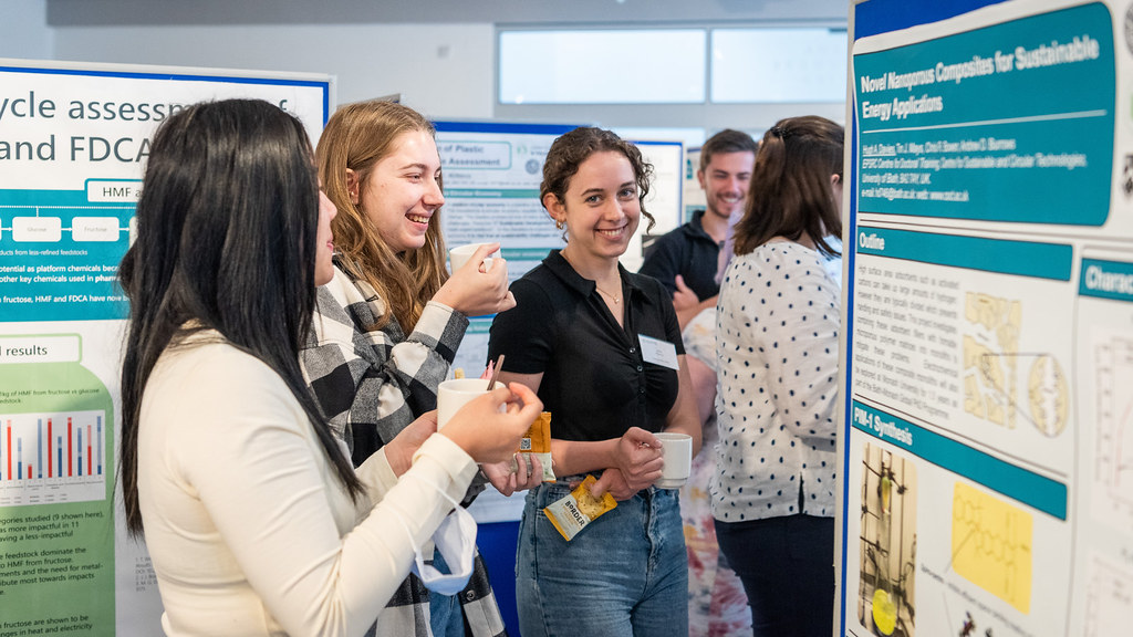 Students gather around a research poster during an event