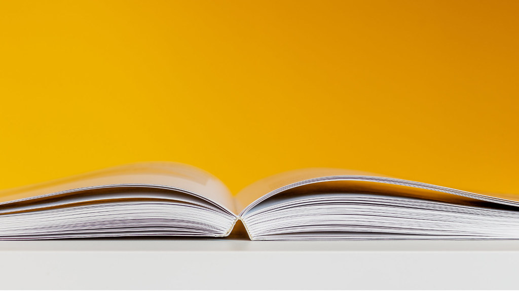 Close-up of an open book on orange background