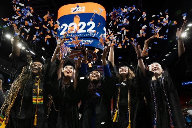 Auburn graduates celebrate with confetti.
