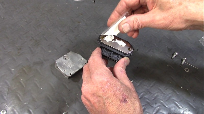 Applying Heat Transfer Paste To Metal Plate On The Back Of Ignition Control Unit