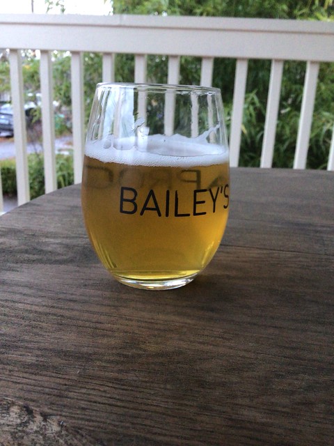 Steeplejack's Kolsch in a glass on a table outside. 