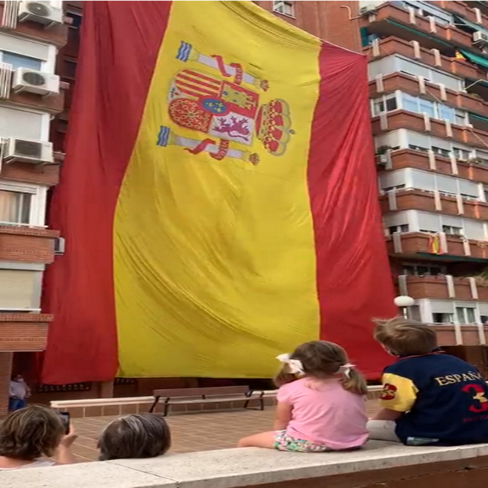 FOTOGRAFÍA. ESPAÑA, 30.05.2020. Día de las Fuerzas Armadas. Un grupo de vecinos celebra el Día de las Fuerzas Armadas izando una gigante bandera. Ñ Pueblo (1)