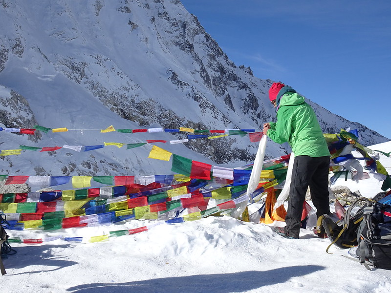 Val adding a khata scarf to the prayer flags at the Larke La