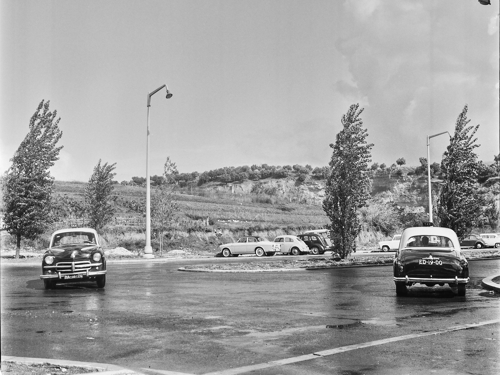 Dois táxis na Av. dos E.U.A. a virar de/para a R. Gulhermina Suggia, Lisboa (A.rnaldo Madureira, 196…)
