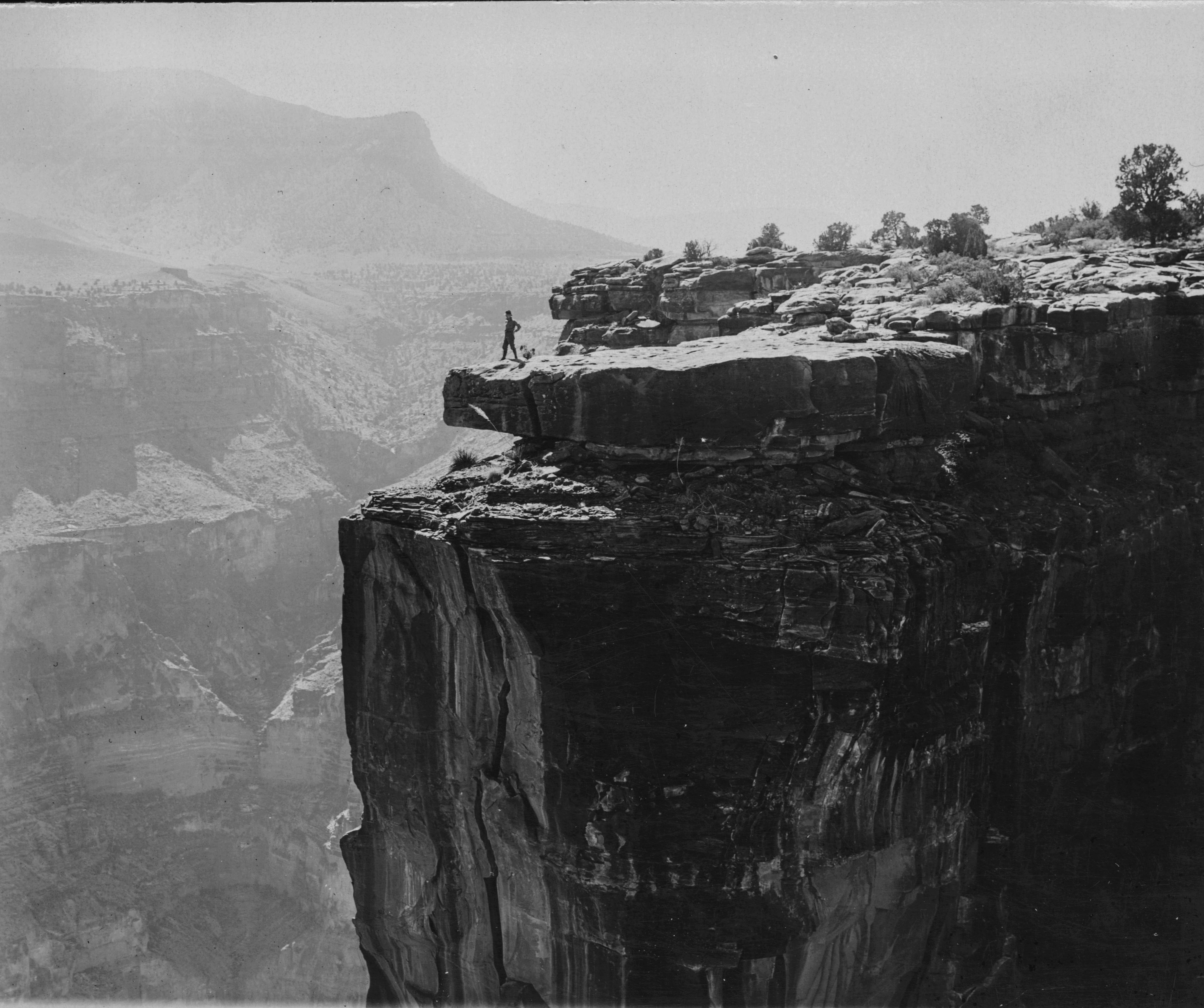 Photograph of a person on the edge of a cliff in the Grand Canyon, Arizona, 1900-1940. | src USC Digital Library