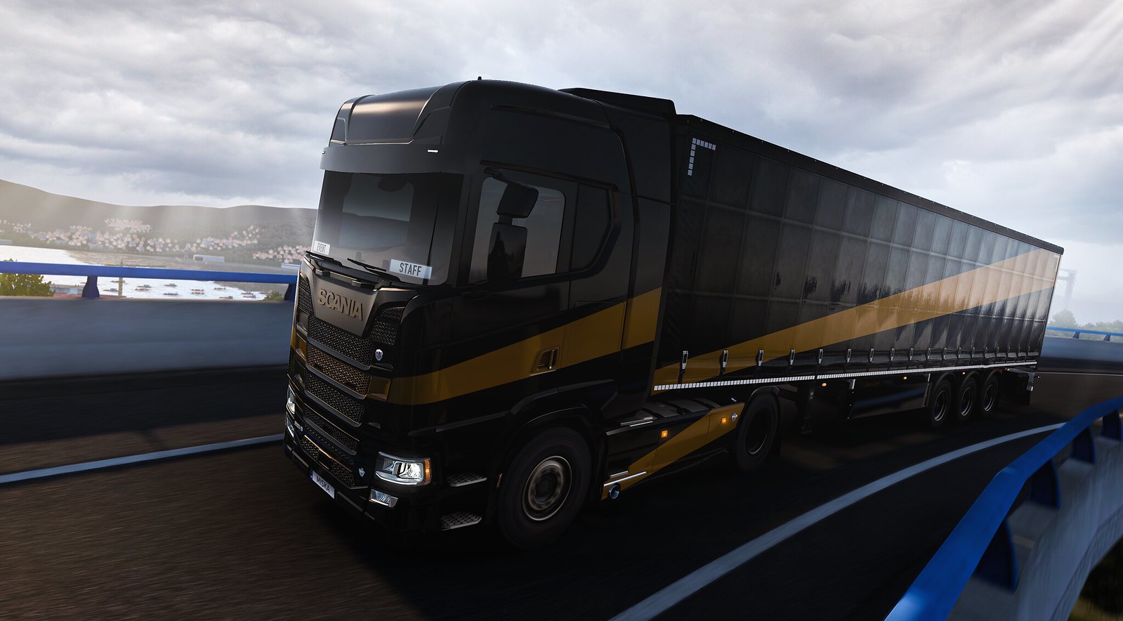 GPE event truck driving along a road in sunny weather, black and gold paint job