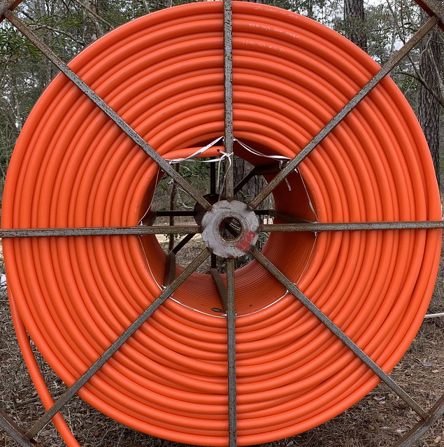 Wheel of vivid orange power line cable to be installed, soon.