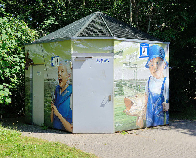 8480 Das Ostseebad   Graal-Müritz   ist eine Gemeinde   im Landkreis Rostock in Mecklenburg-Vorpommern; öffentliche Toilette mit Wandmalerei in Müritz - Junge, Angler mit Fisch - Mädchen mit Schuh