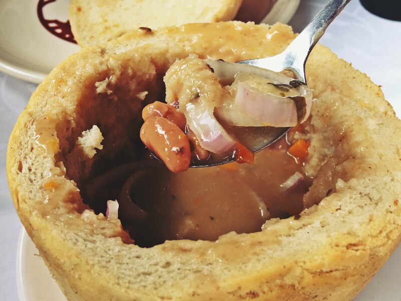 Bean soup served inside a bowl made from a hollow bread.