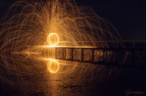 smileonsaturday lightpainting steelwoolspinning jetty water reflections steelwoolphotography orange fire light dark flicks2305 flicks2307