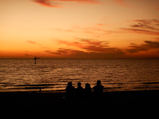 Beachgoers enjoying the skies after sunset at Elwood Beach on a warm Summer Monday