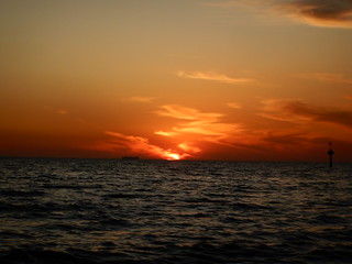Sunset, half remaining, at Elwood Beach on a warm Summer Monday