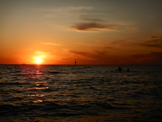 Beachgoers swimming at sunset at Elwood Beach on a warm Summer Monday