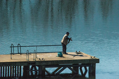 A Man Fishing  On A Jetty In The River Duoro