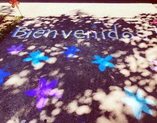 Photo of chalk drawing on sidewalk that says bienvenido