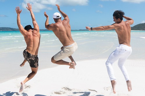 A picture of three people jumping for joy on the beach during their vacation with Royal Holiday Vacation Club.