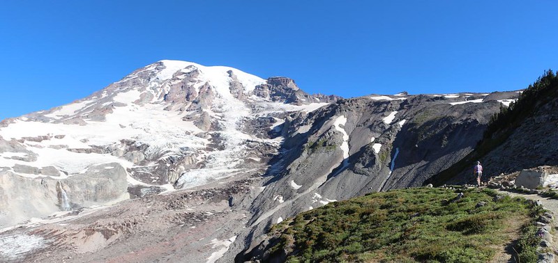 Panorama view of Mount Rainier, with Vicki hiking on the Skyline Trail, far right