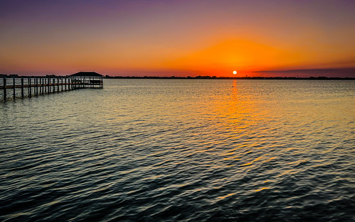 melbournebeach florida unitedstates sunset over indian river lagoon with fishing pier melbourne beach fl dusk yellow sun orange water sea bay tranquility calm serenity placid peaceful idyllic scenic