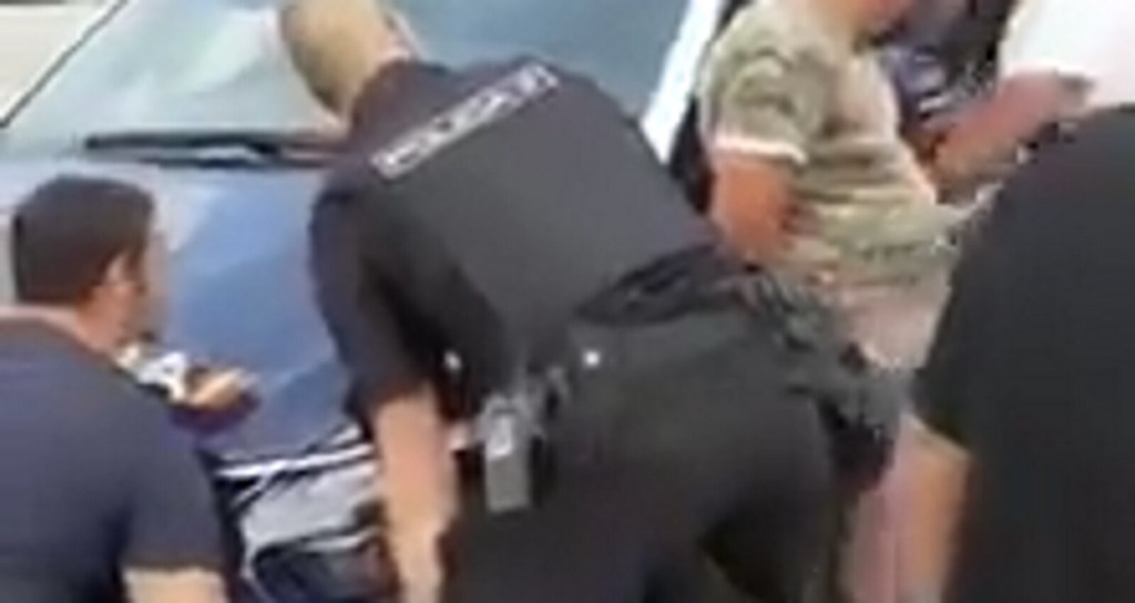 FOTOGRAFÍA. ESPAÑA, JUNIO DE 2020. Un grupo de personas de la comunidad gitana ayuda a dos agentes de Policía Nacional a mover el coche de patrulla atrapado en una horquilla guarda acera. (Ñ Pueblo) (4)