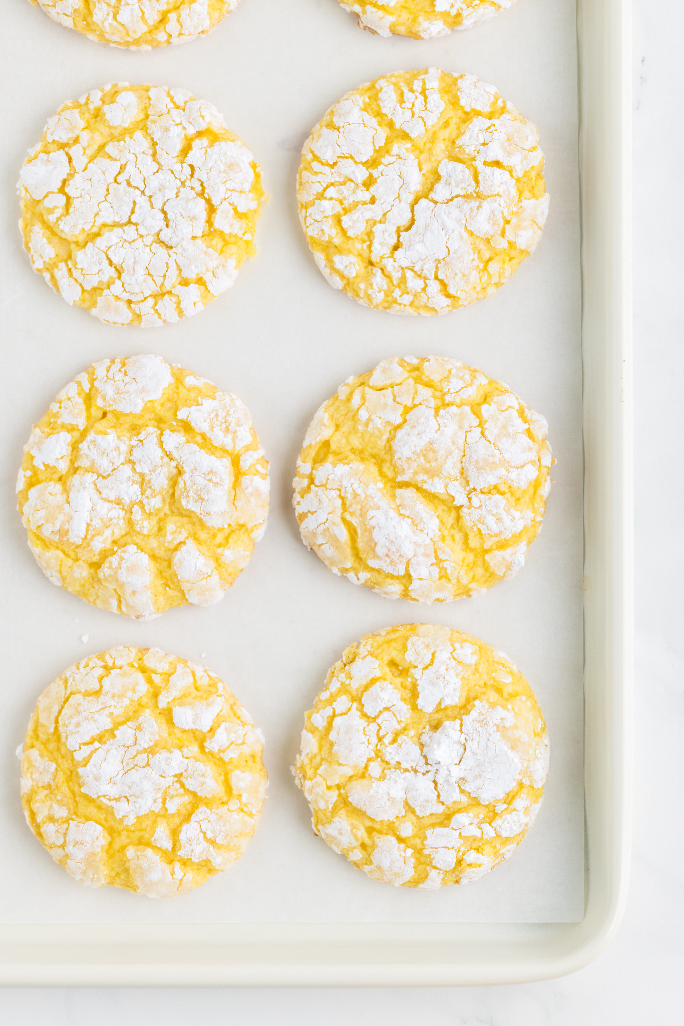 6 lemon crinkle cookies on a baking sheet