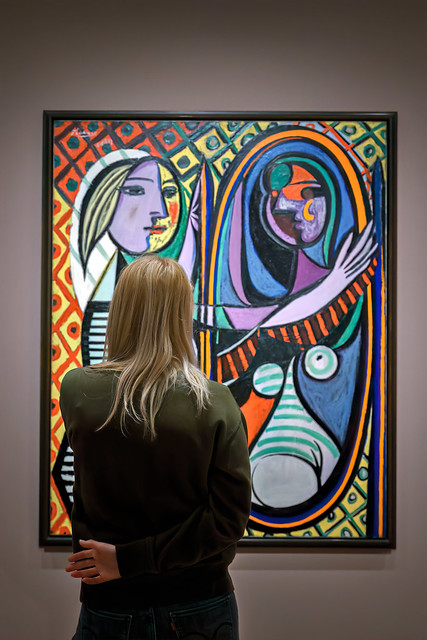 Blonde woman looking at Pablo Picasso's painting 