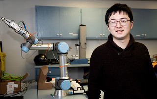 Dongyi Wang with robotic arm in his lab.