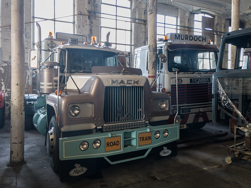 A photo of some large trucks inside an old factory building.