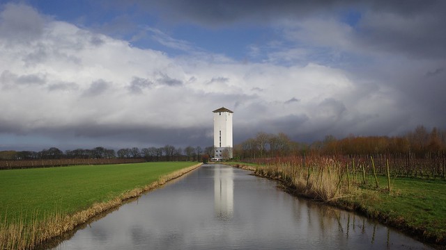 Cloudy skies and water tower with lots of contrast