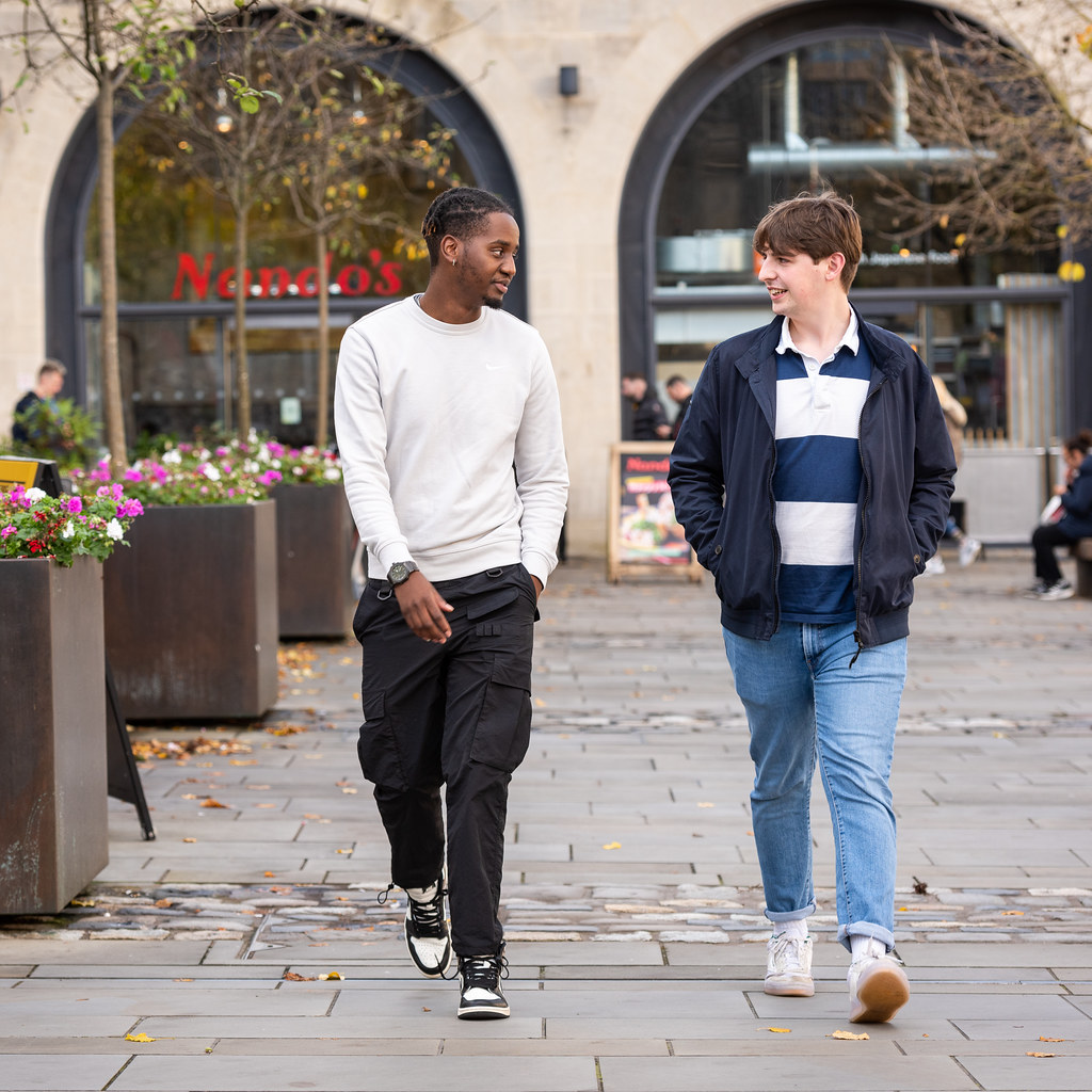Two students walking together in the city centre.