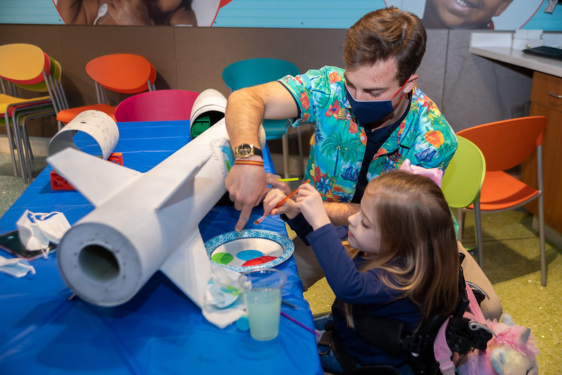 An Auburn engineering student paints a rocket with a young patient at Children’s of Alabama