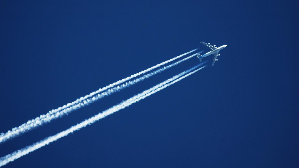 Jet plane with contrails against a blue sky