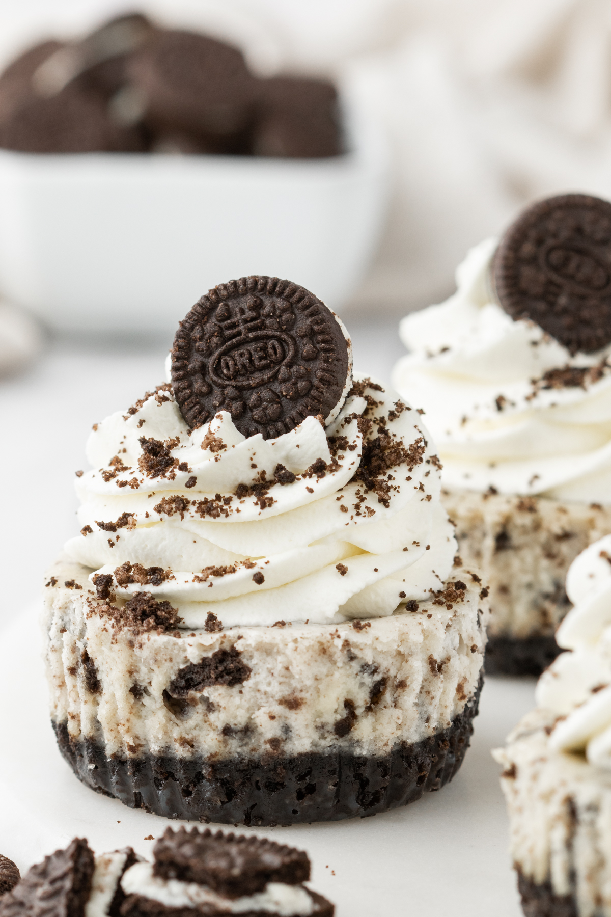 Creamy and delicious Mini Oreo Cheesecakes on an Oreo crust and topped with whipped cream and more Oreos. A must make for Oreos lovers! They are so simple and bake in a muffin pan. 