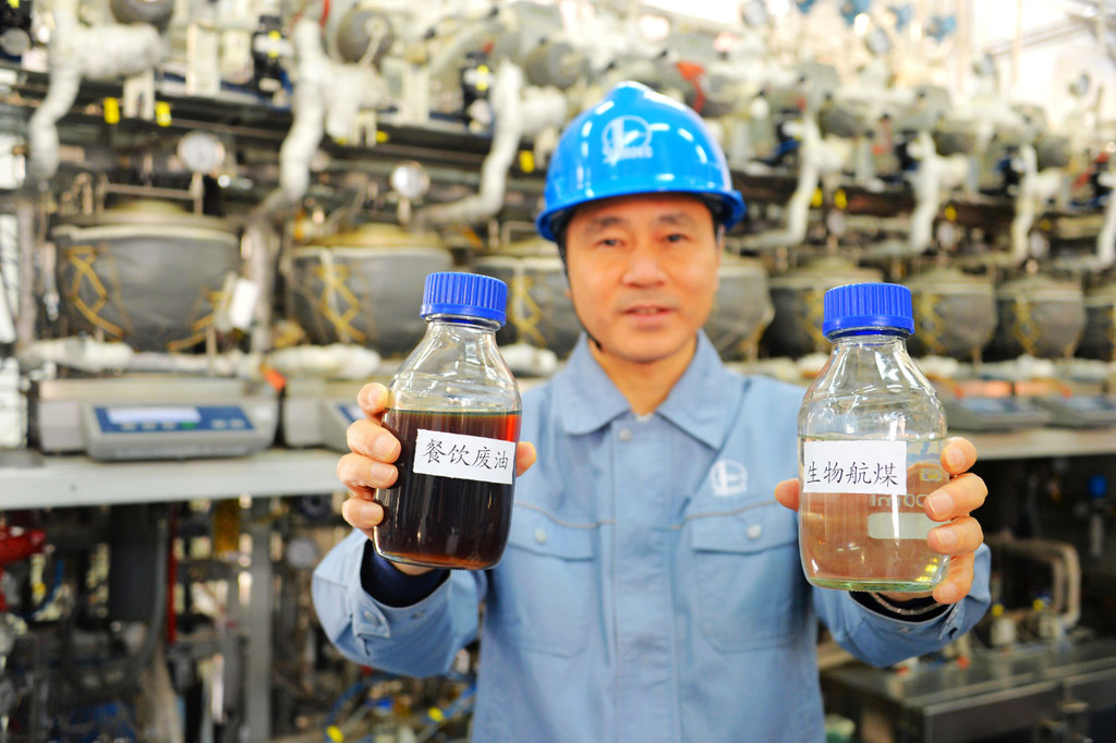 2017年11月20日，中石化石油化工科學研究院的一名科學家在北京的研究基地展示了生物航空煤油和餐飲廢油。 圖片來源：Alamy