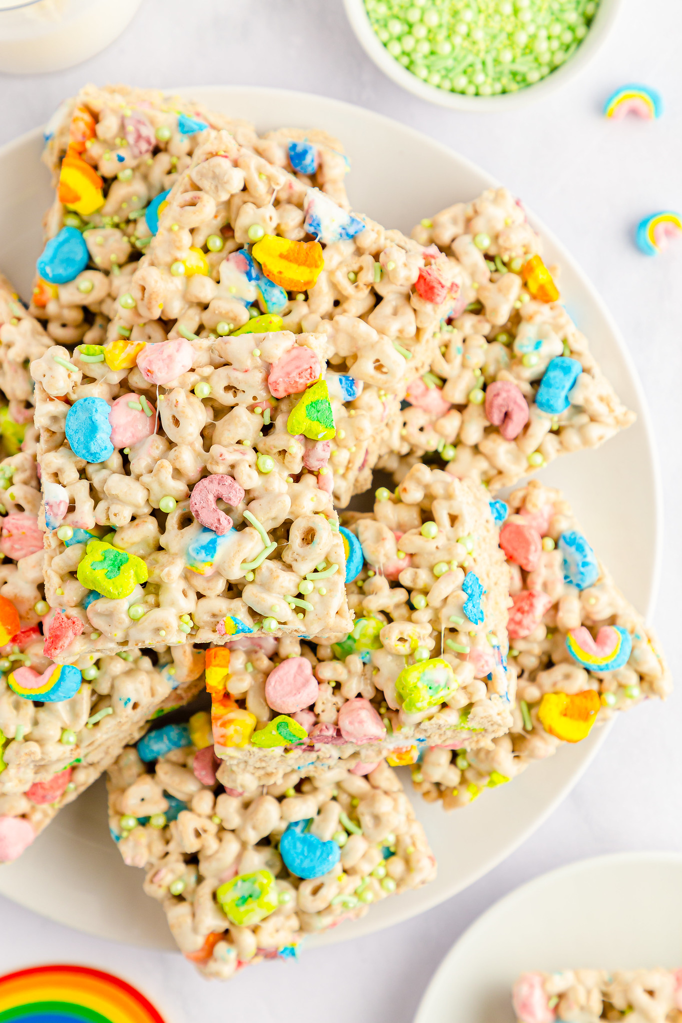 overhead shot of rice krispies treats made with lucky charms and topped with extra lucky charms marshmallows and sprinkles
