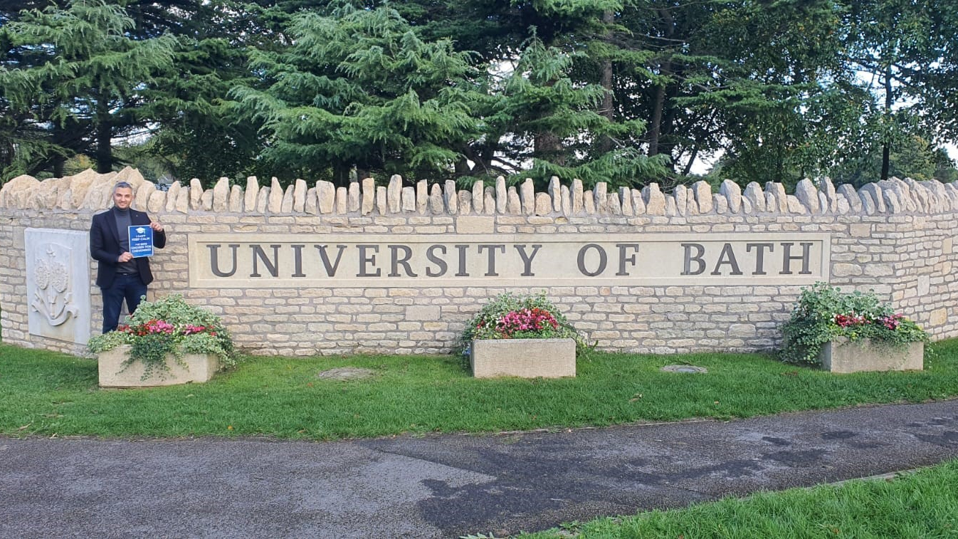 Amjad Bani Al-margah standing in front of the University of Bath sign