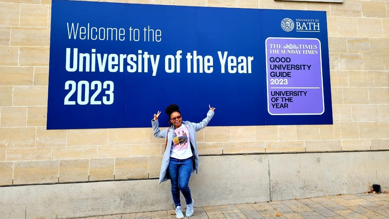 Chevening Scholar Mantsebeng Suzan Maepe in front of the 'Welcome to the University of the Year' sign