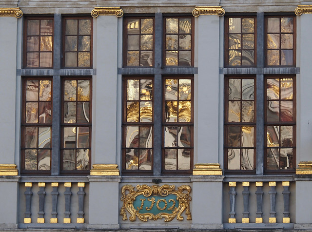 Reflections of Brussel's Grand Place in the window of a baroque building